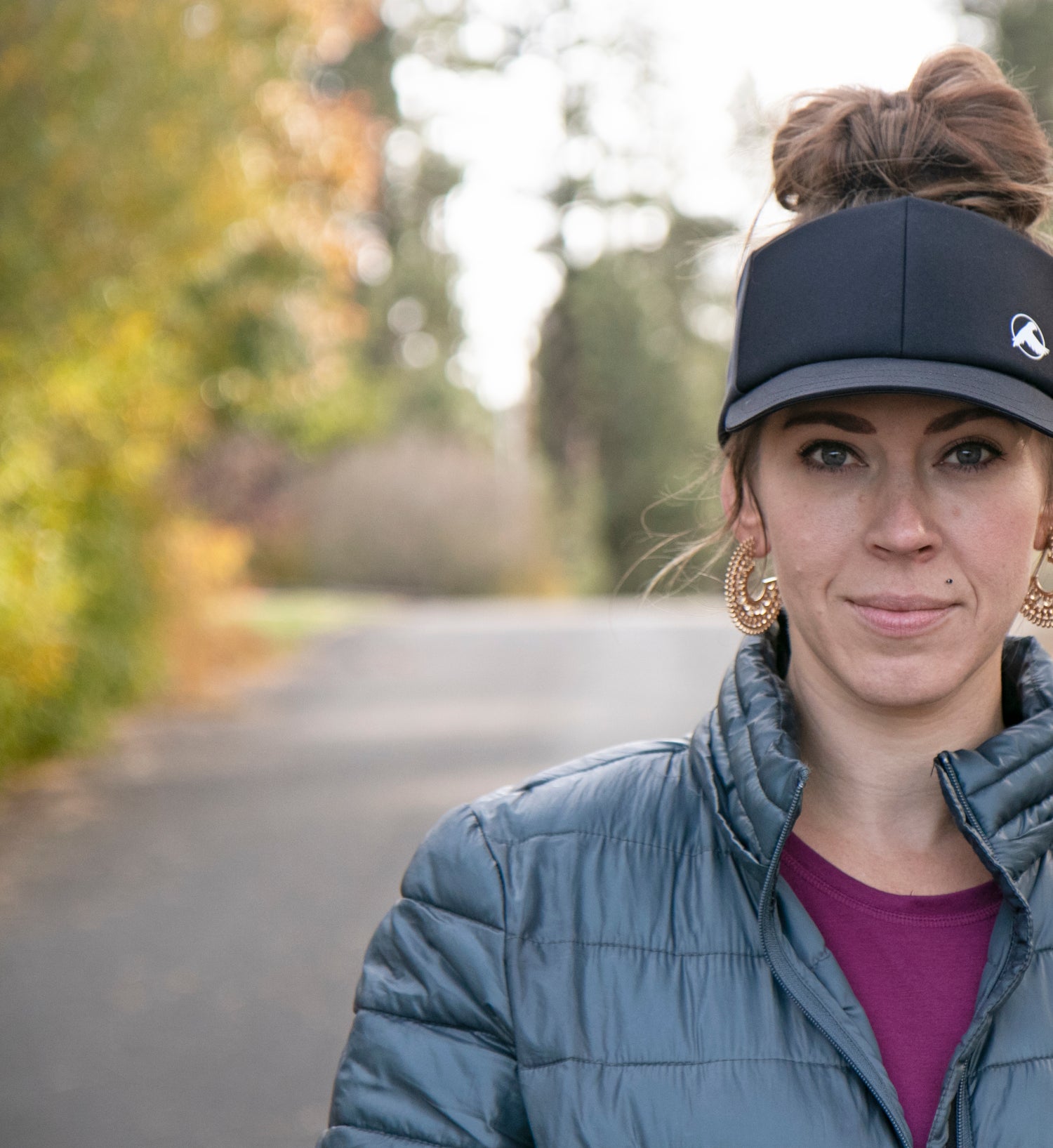 trucker visor, taller visor for trail running on a woman with a top knot bun